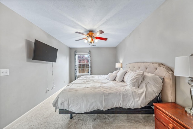 carpeted bedroom featuring baseboards and a ceiling fan