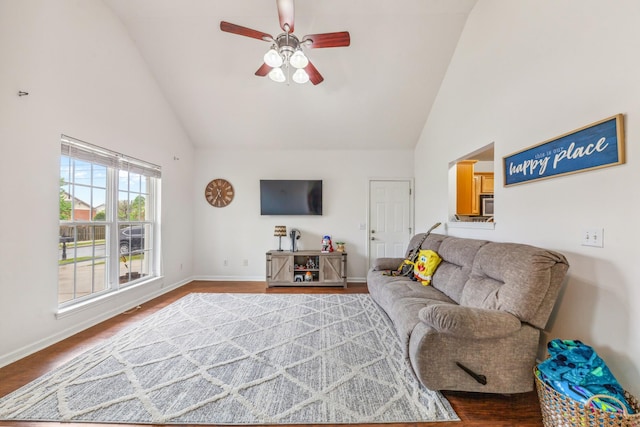 living area with high vaulted ceiling, ceiling fan, and baseboards
