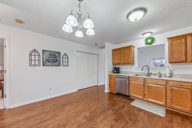 kitchen featuring dark wood finished floors, dishwasher, light countertops, and a sink