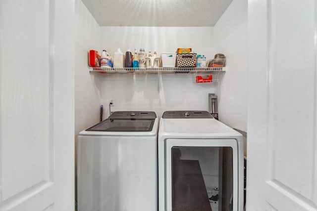 clothes washing area featuring separate washer and dryer and laundry area