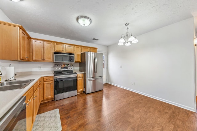 kitchen featuring an inviting chandelier, stainless steel appliances, light countertops, a sink, and visible vents
