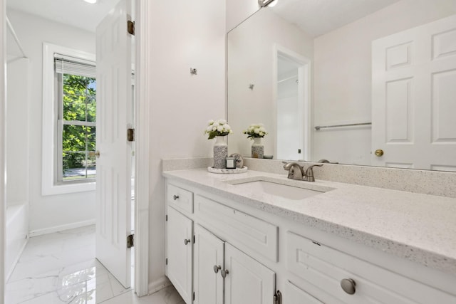 full bathroom featuring baseboards, marble finish floor, and vanity