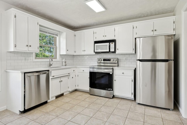 kitchen featuring a sink, appliances with stainless steel finishes, tasteful backsplash, and light countertops