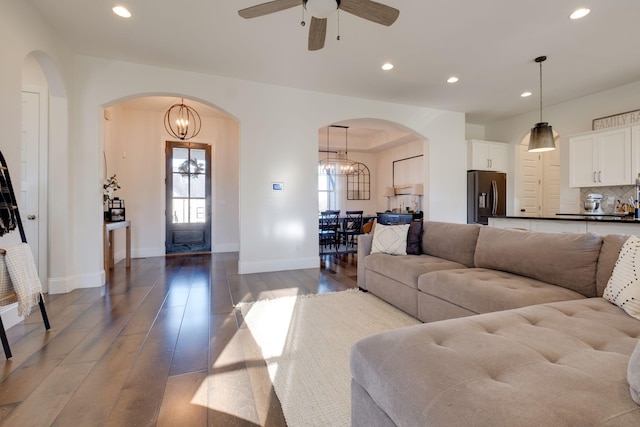 living room featuring recessed lighting, hardwood / wood-style floors, baseboards, and ceiling fan with notable chandelier