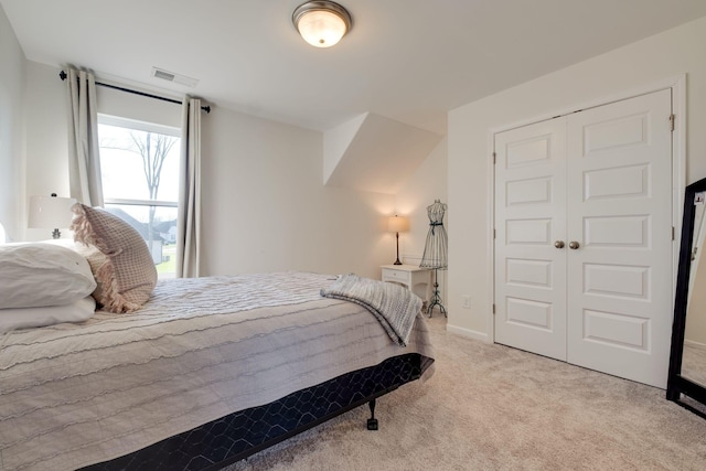 bedroom with carpet flooring, visible vents, and a closet