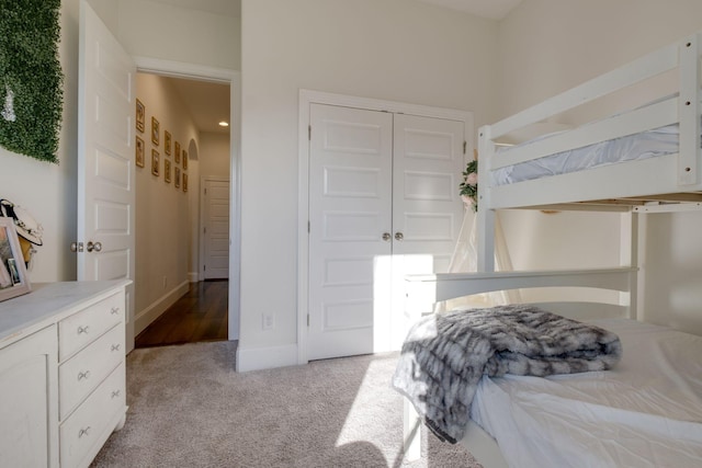 bedroom featuring carpet, baseboards, and a closet