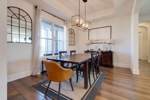 dining room with baseboards, arched walkways, ornamental molding, and dark wood-type flooring