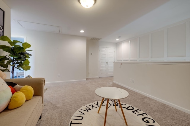 living area with attic access, visible vents, light colored carpet, and recessed lighting
