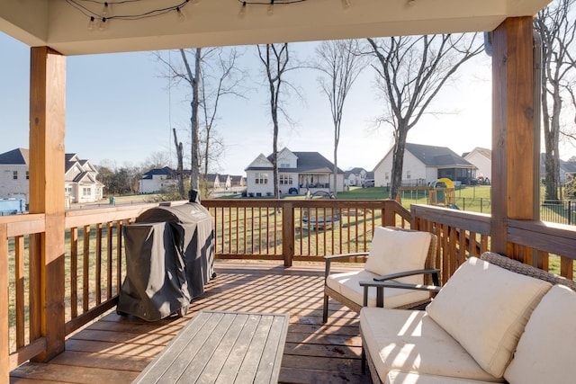 wooden deck featuring area for grilling, a yard, and a residential view