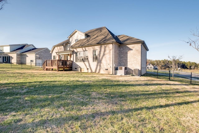 back of property with a deck, a yard, a fenced backyard, and brick siding
