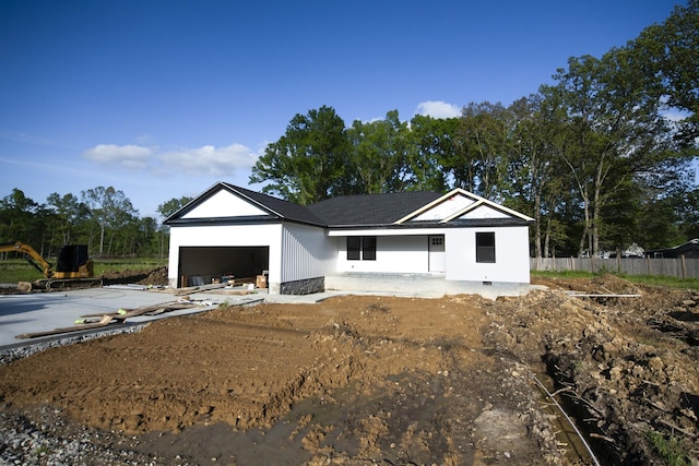 back of house with driveway, fence, and an attached garage