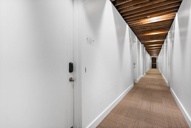 hall featuring wooden ceiling and baseboards