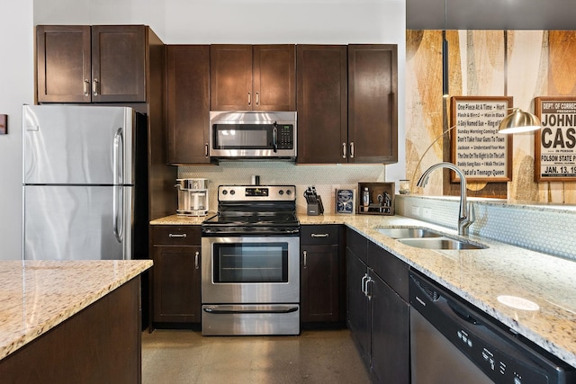 kitchen with a sink, stainless steel appliances, dark brown cabinetry, light stone counters, and backsplash