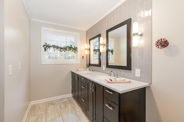 full bathroom with double vanity, a sink, baseboards, visible vents, and crown molding