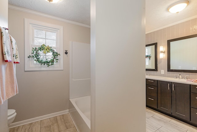full bathroom featuring a textured ceiling, toilet, ornamental molding, vanity, and backsplash