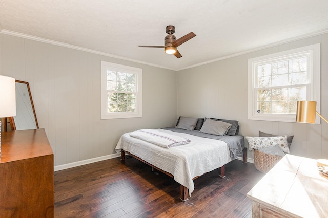 bedroom with crown molding, dark wood-style floors, a ceiling fan, and baseboards