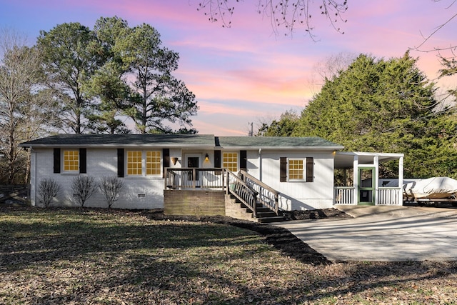 ranch-style home with brick siding, a front yard, driveway, and crawl space