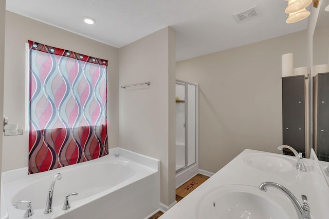 full bathroom featuring a sink, a garden tub, a stall shower, and visible vents
