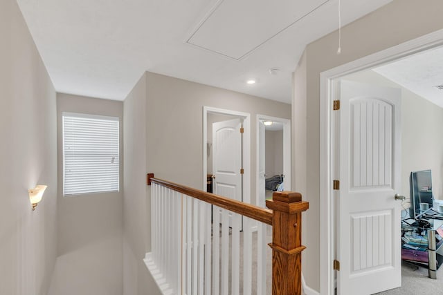 hallway with baseboards and attic access