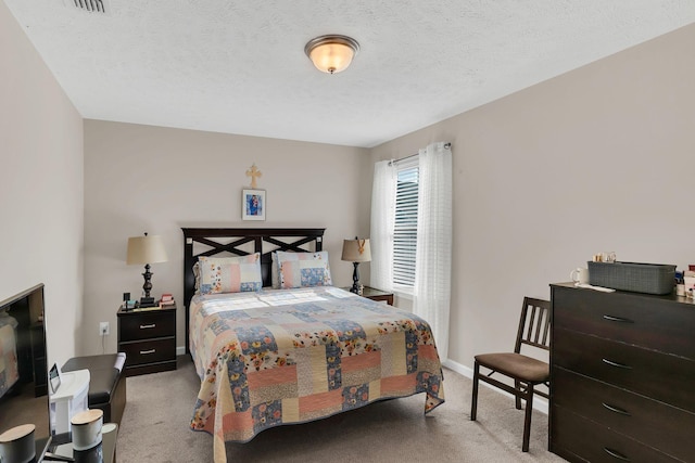 carpeted bedroom featuring baseboards and a textured ceiling