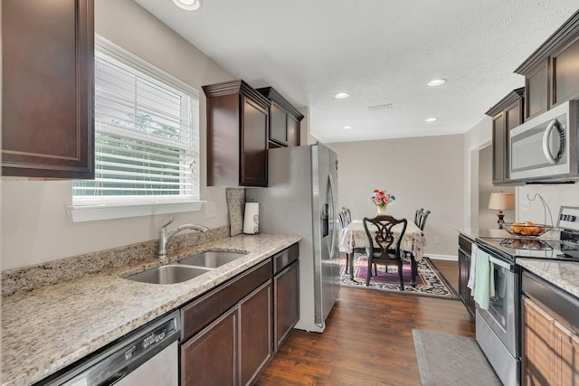 kitchen featuring a sink, dark brown cabinetry, stainless steel appliances, and dark wood-style flooring