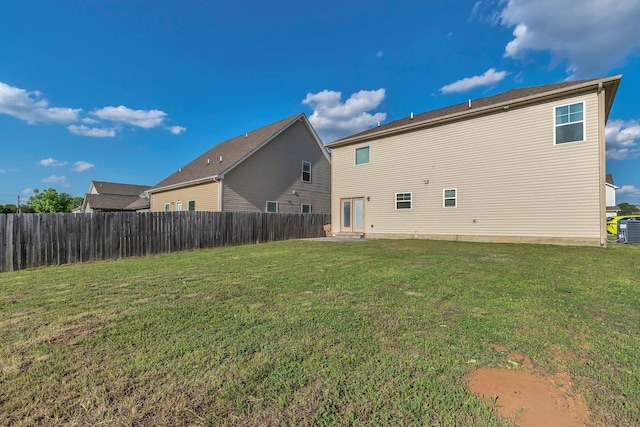 rear view of property with a lawn, fence, and central air condition unit