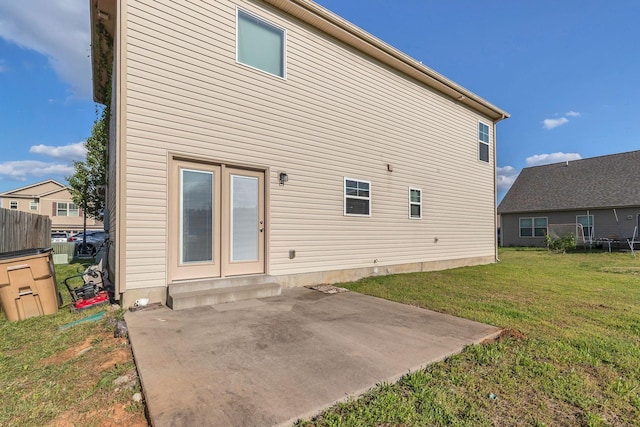rear view of house featuring a patio area and a yard