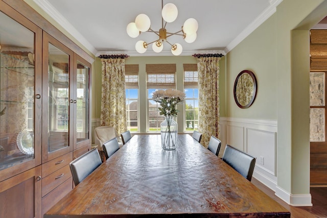 unfurnished dining area with wood finished floors, an inviting chandelier, a decorative wall, wainscoting, and crown molding