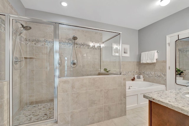 full bath featuring a garden tub, vanity, tile patterned flooring, and a stall shower