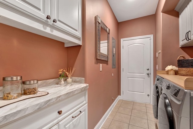 laundry room featuring baseboards, washer and dryer, cabinet space, and light tile patterned flooring