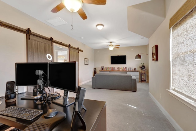 carpeted home office with a ceiling fan, visible vents, a barn door, and baseboards