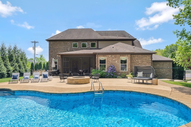 pool with a fire pit, fence, and a patio area