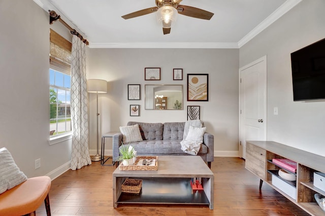 living area with baseboards, ornamental molding, ceiling fan, and wood finished floors