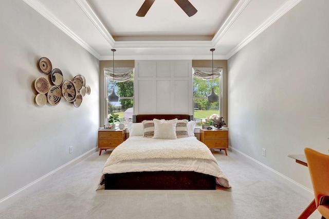 bedroom with ornamental molding, light carpet, baseboards, a ceiling fan, and a tray ceiling