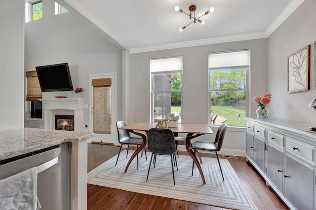 dining space featuring a wealth of natural light, dark wood-style flooring, and crown molding