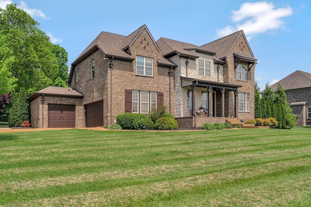 view of front of house featuring a front lawn, brick siding, and a garage
