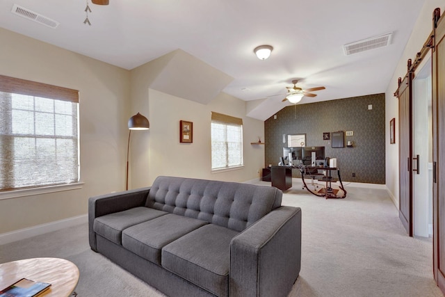 living area featuring visible vents, a ceiling fan, and light carpet