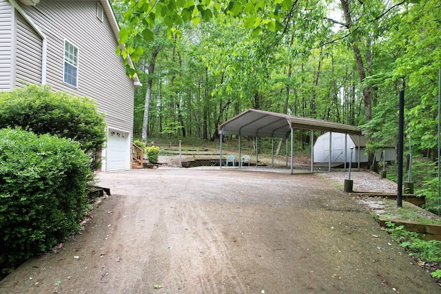 100 Treeann Ln, Ringgold, GA 30736 - view of vehicle parking with a storage unit, aphalt driveway, a carport, and an attached garage