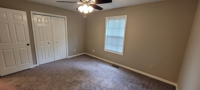 unfurnished bedroom featuring carpet floors, a closet, ceiling fan, baseboards, and visible vents