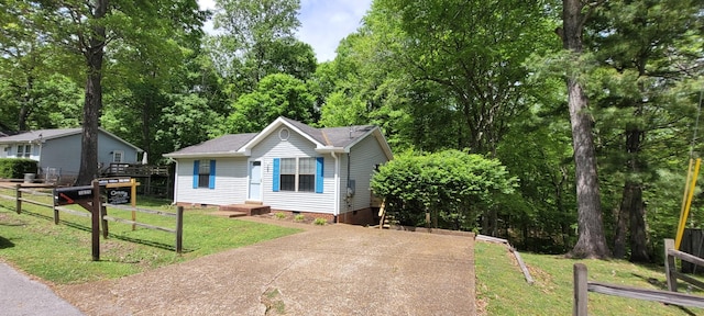 view of front of home with fence, a front yard, and crawl space