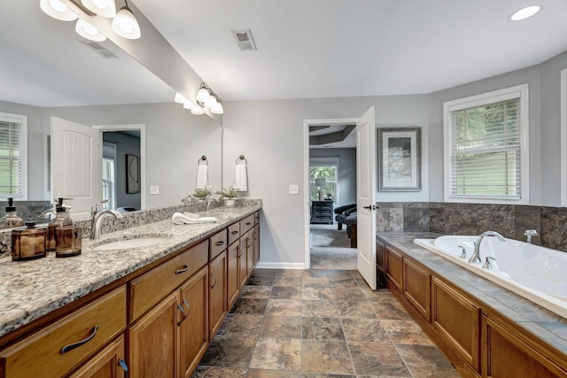 1199 Ben Hill Blvd, Nolensville, TN 37135 - full bathroom with double vanity, connected bathroom, a garden tub, and stone finish flooring