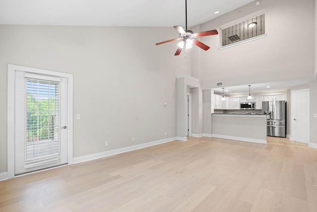 3201 Aspen Grove Dr Unit L8, Franklin, TN 37067 - unfurnished living room featuring light wood-type flooring, baseboards, ceiling fan, and a high ceiling
