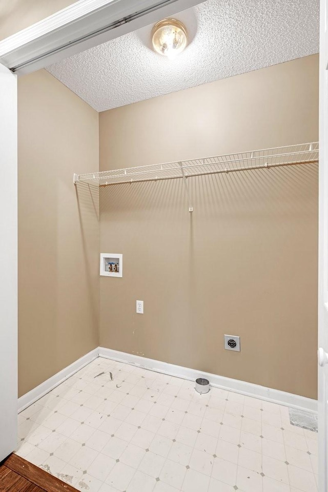 washroom featuring electric dryer hookup, hookup for a washing machine, light floors, and baseboards
