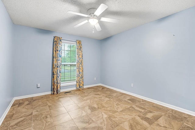 empty room with baseboards, visible vents, ceiling fan, and a textured ceiling