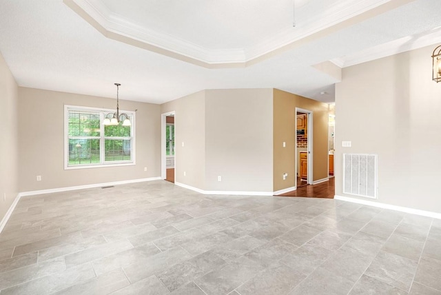 unfurnished room with a notable chandelier, a raised ceiling, crown molding, visible vents, and baseboards