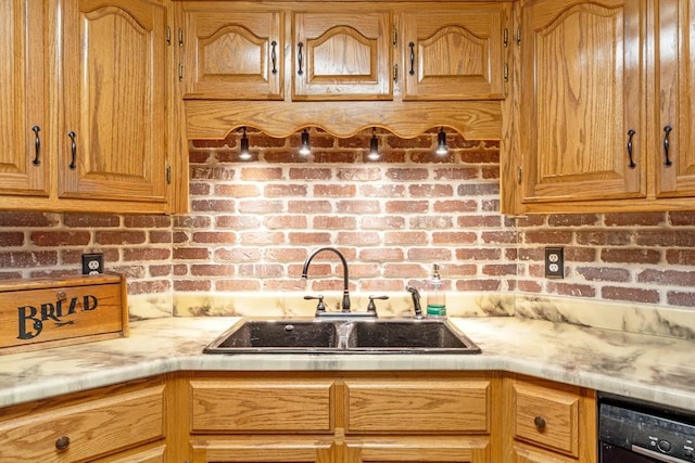kitchen with black dishwasher, light countertops, and a sink