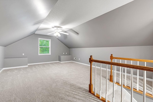 bonus room featuring ceiling fan, vaulted ceiling, carpet floors, and baseboards