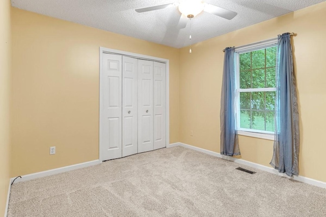 unfurnished bedroom featuring a closet, carpet flooring, baseboards, visible vents, and a ceiling fan