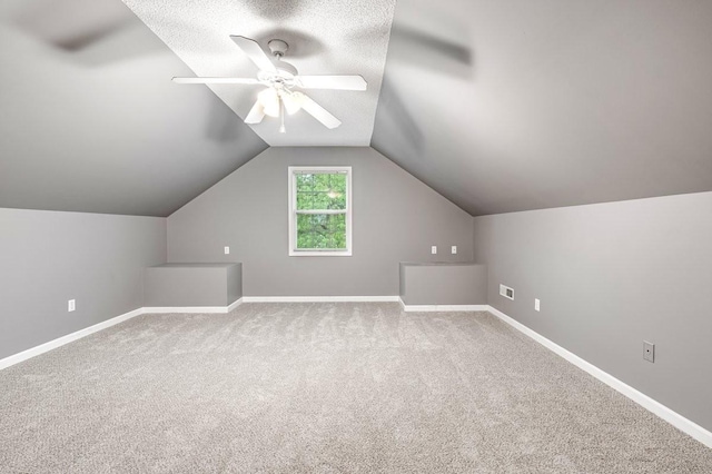 additional living space featuring baseboards, a ceiling fan, carpet flooring, and vaulted ceiling