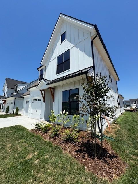 5738 Lennis Ln, Murfreesboro, TN 37129 - view of front of house with board and batten siding, driveway, an attached garage, and a front yard